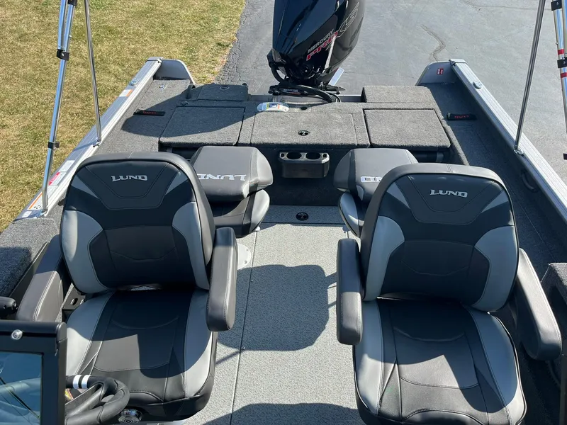 Slide: The Image of 2025 Lund 2075 Impact XS Sport boat interior with two cushioned seats and motor. - 24