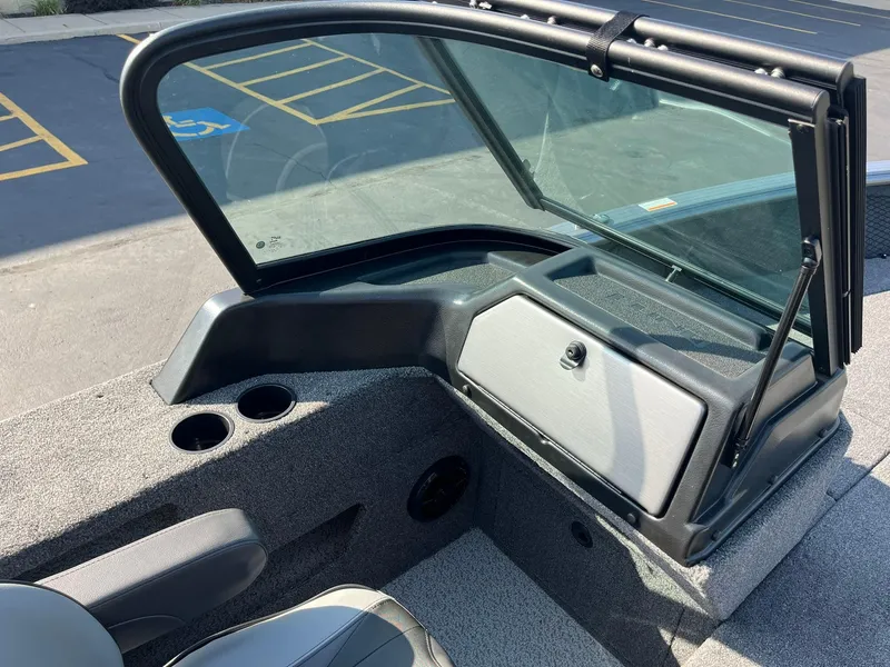 Slide: The Image of 2025 Lund 2075 Impact XS Sport boat interior with windshield and storage compartment. - 27