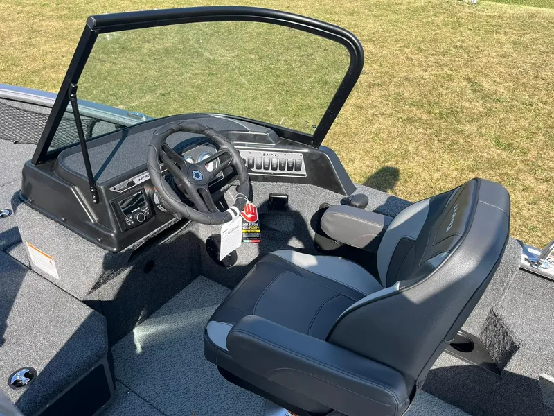 Slide: The Image of 2025 Lund 2075 Impact XS Sport boat interior with steering wheel and captain's chair. - 28