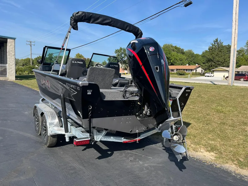 Slide: The Image of 2025 Lund 2075 Impact XS Sport boat on trailer, parked outdoors. - 3