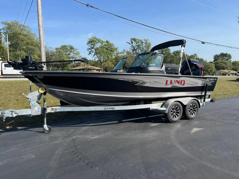 Slide: The Image of 2025 Lund 2075 Impact XS Sport boat on trailer, parked outdoors. - 4
