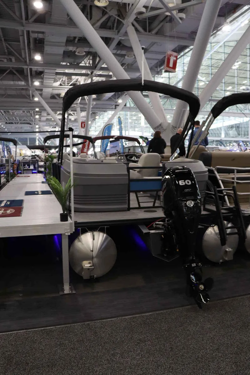 Slide: The Image of 2025 Starcraft GX 22R DH SPORT boat displayed indoors with outboard motor. - 3