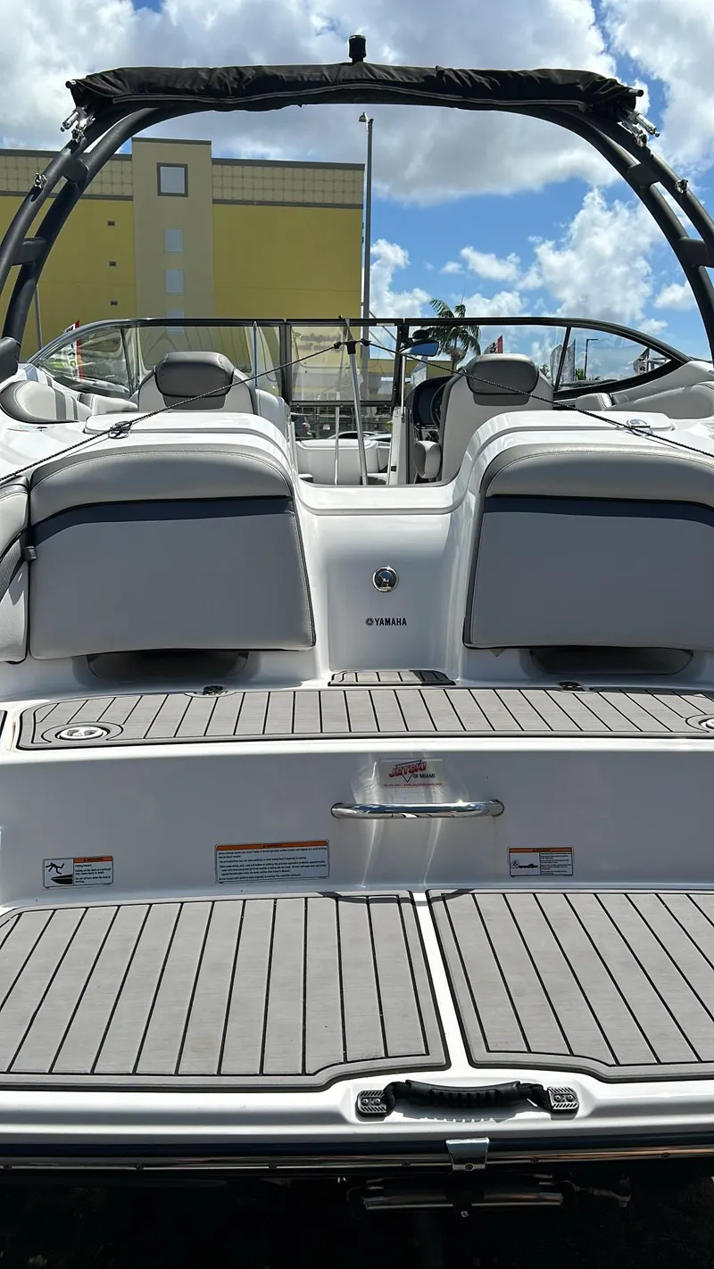 Slide: The Image of 2019 Yamaha Boats AR240 with sleek design and spacious deck under a sunny sky. - 13