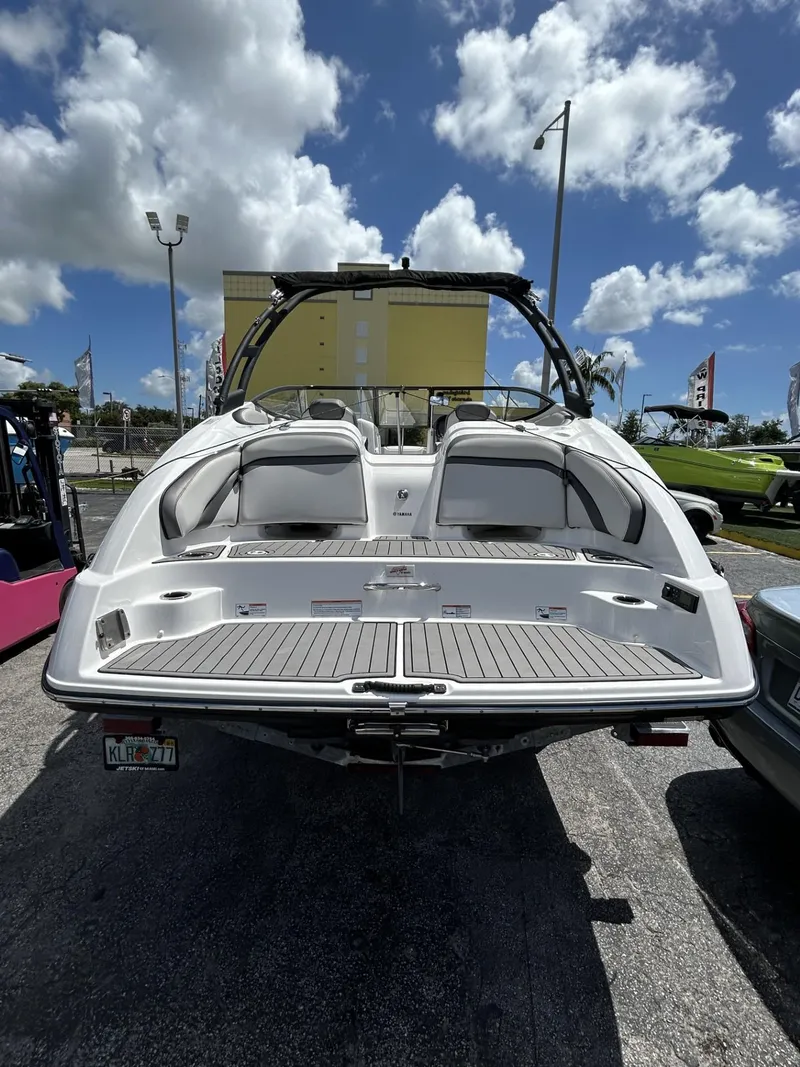 Slide: The Image of 2019 Yamaha AR240 boat, rear view, parked outdoors under a cloudy sky. - 26