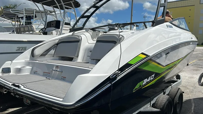 Slide: The Image of 2019 Yamaha Boats AR240 on trailer, sleek design, white and green accents, sunny day. - 3