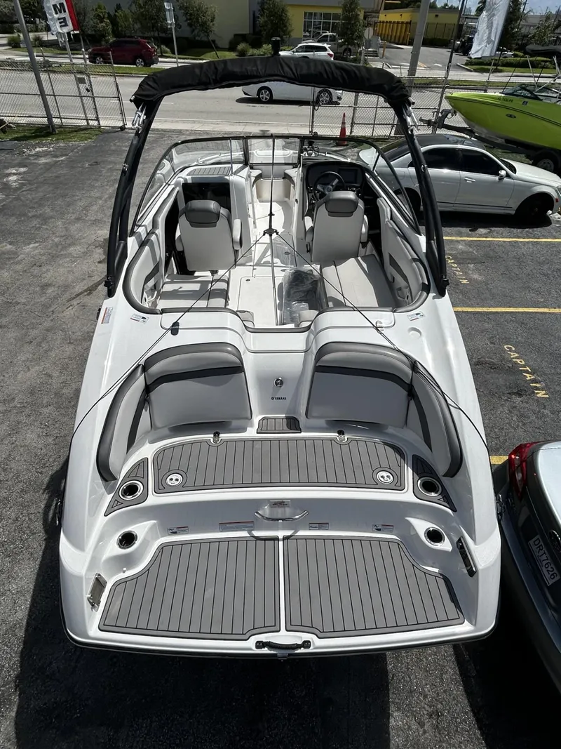 Slide: The Image of 2019 Yamaha Boats AR240, sleek design, spacious interior, docked in a parking lot. - 6