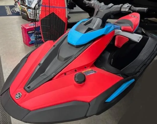 Slide: The Image of 2025 Yamaha WaveRunner JetBlaster DLX 2-Up in vibrant red and blue, displayed indoors. - 2