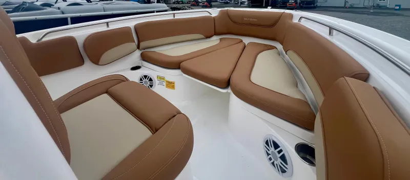 Slide: The Image of 2025 NauticStar 212 Legacy boat interior with helm and seating under cloudy sky. - 4