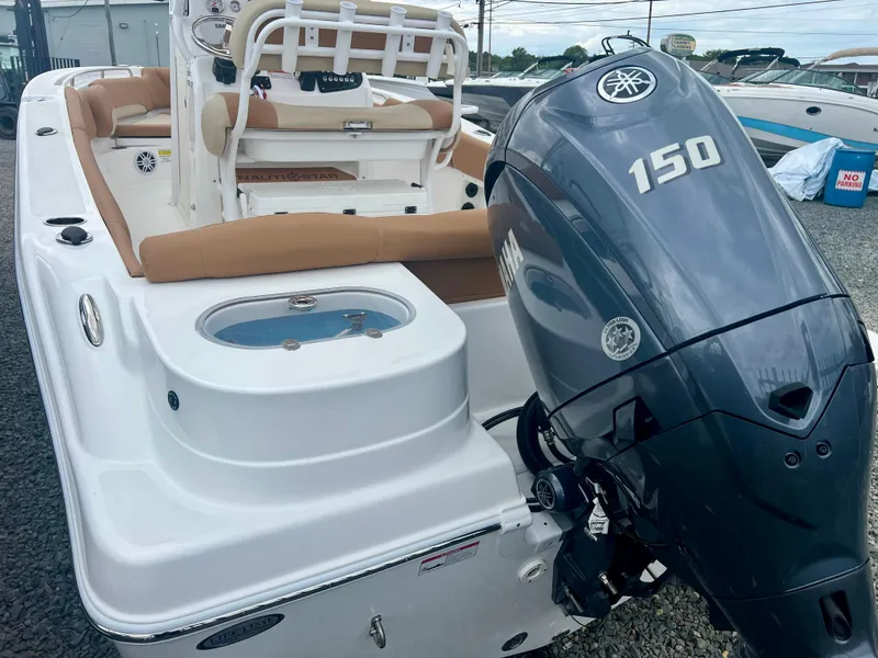 Slide: The Image of 2025 NauticStar 212 Legacy boat with tan cushioned seating and built-in speakers. - 6