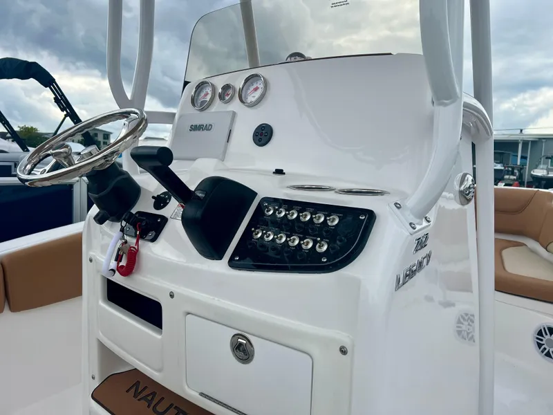 Slide: The Image of 2025 NauticStar 212 Legacy boat interior with tan seating and canopy. - 7