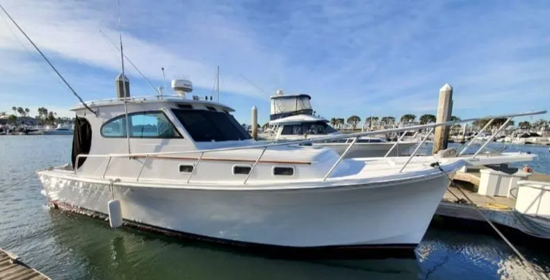 Slide: The Image of 1999 Mainship 30 boat docked in a marina under a clear blue sky. - 17