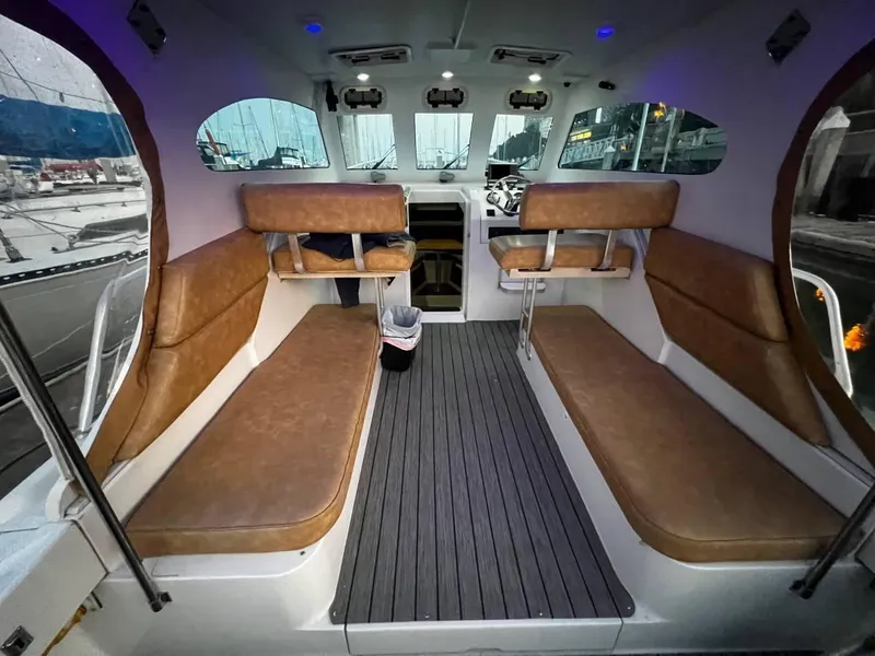 Slide: The Image of Interior of 1999 Mainship 30 boat with brown seating and modern design. - 5