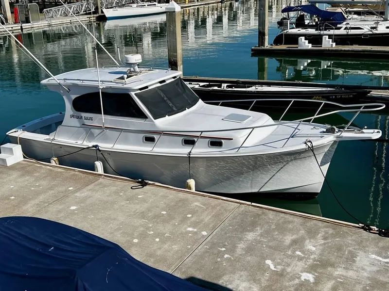 Slide: The Image of 1999 Mainship 30 boat docked at marina, calm water reflections. - 6