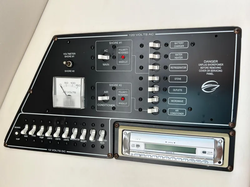 Slide: The Image of Electrical control panel of a 2006 Crownline 250cr boat with various switches and a Sony stereo. - 11