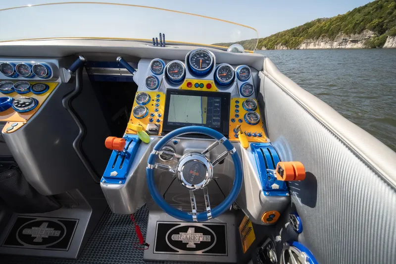 Slide: The Image of 2007 Cigarette 42X boat dashboard with gauges and steering wheel on a lake. - 11