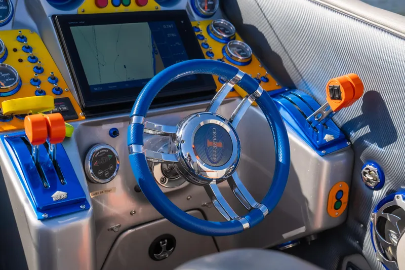 Slide: The Image of 2007 Cigarette 42X boat dashboard with blue steering wheel and navigation controls. - 19