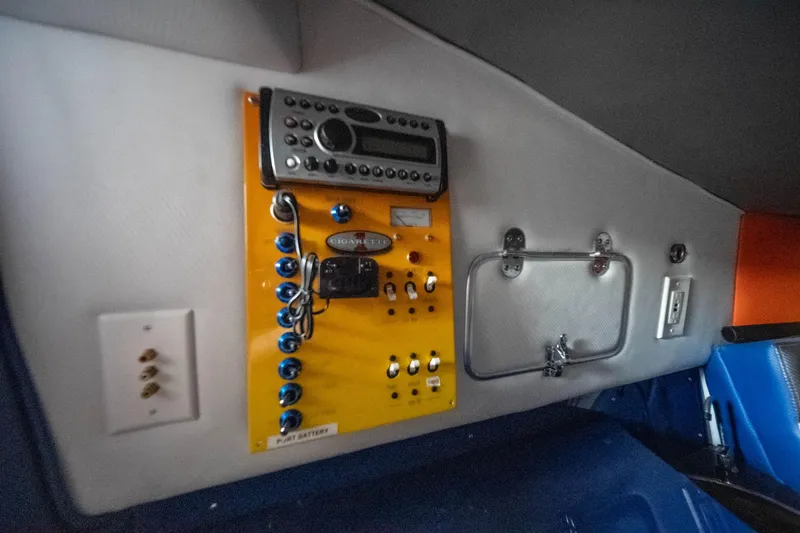 Slide: The Image of Control panel inside 2007 Cigarette 42X boat, featuring switches and a stereo system. - 24