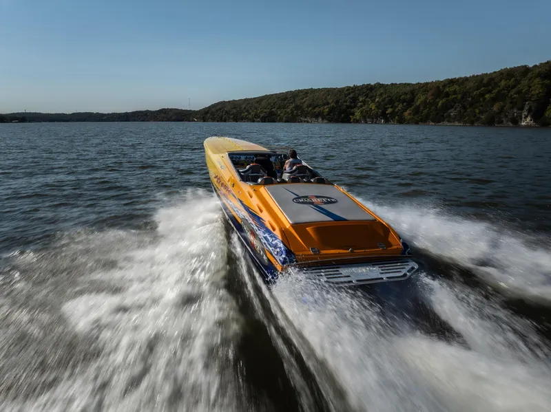 Slide: The Image of 2007 Cigarette 42X speedboat cruising on a lake with scenic forested shoreline. - 3