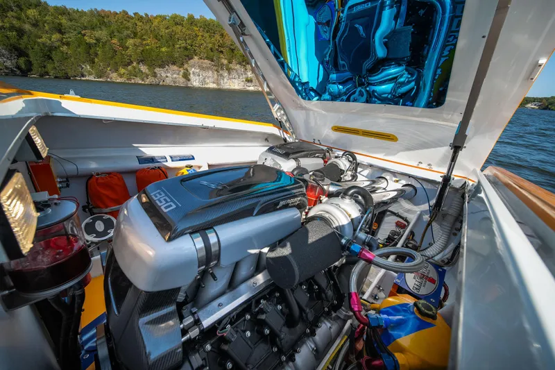 Slide: The Image of 2007 Cigarette 42X boat engine compartment with high-performance components, open hatch, and scenic lake backdrop. - 32