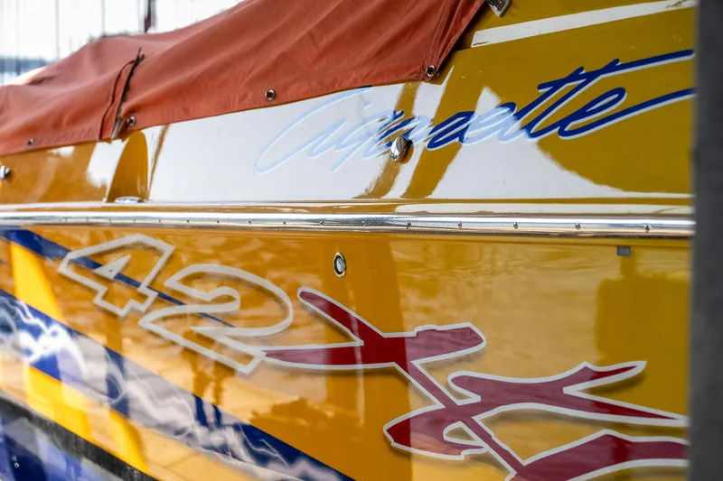 Slide: The Image of Close-up of a 2007 Cigarette 42X boat with vibrant yellow and red graphics. - 39