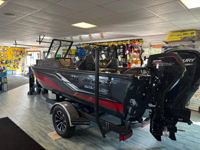 Slide: The Image of 2025 Crestliner 1750 Fish Hawk WT JS boat displayed indoors with Mercury engine. - 10