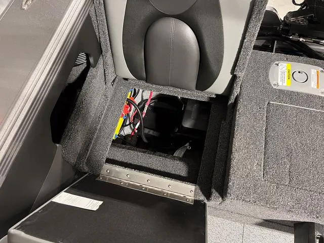Slide: The Image of 2025 Lund 2075 Tyee Sport boat interior with open storage compartment and visible wiring. - 11
