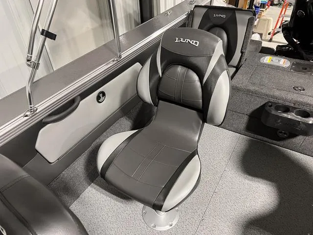 Slide: The Image of 2025 Lund 2075 Tyee Sport boat interior with sleek black and gray seating. - 17