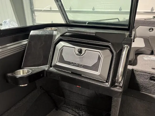 Slide: The Image of Interior of 2025 Lund 2075 Tyee Sport boat, featuring storage compartment and cup holder. - 22