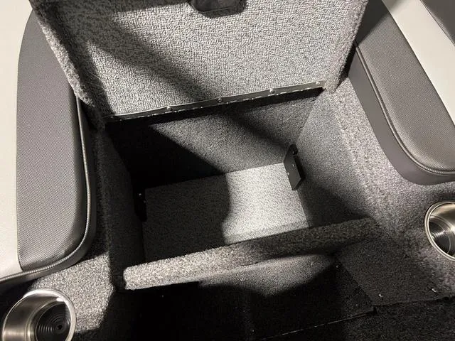 Slide: The Image of 2025 Lund 2075 Tyee Sport boat storage compartment with cup holders and cushioned seating. - 25