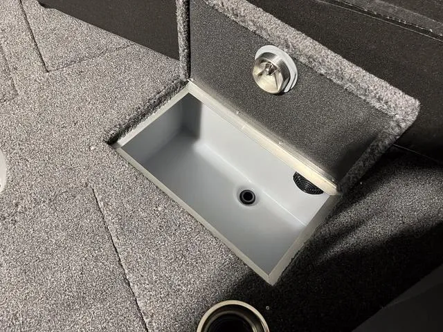 Slide: The Image of 2025 Lund 2075 Tyee Sport boat storage compartment with carpeted interior. - 27