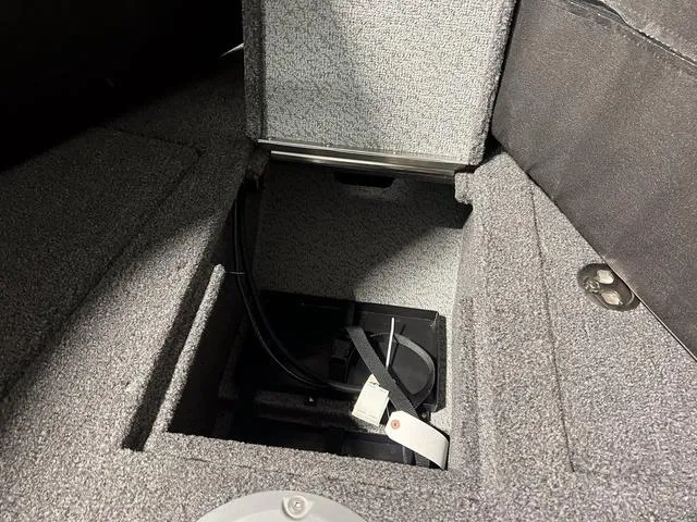 Slide: The Image of 2025 Lund 2075 Tyee Sport boat storage compartment with open hatch and cables. - 28