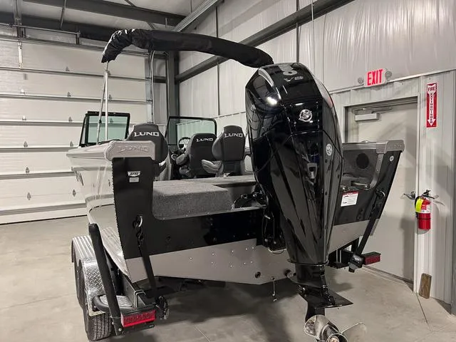 Slide: The Image of 2025 Lund 2075 Tyee Sport boat in garage, featuring powerful outboard motor. - 4