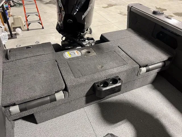 Slide: The Image of 2025 Lund 2075 Tyee Sport boat interior with Mercury engine, featuring storage and seating. - 6