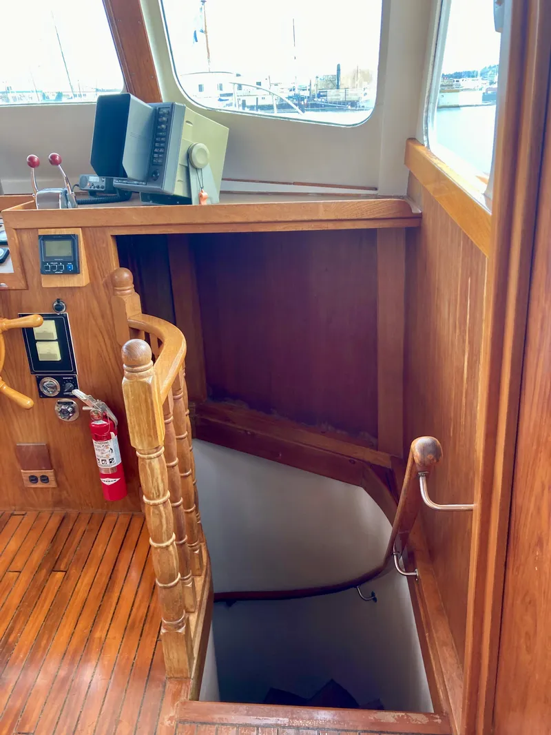 Slide: The Image of 1977 Grand Alaskan Raised Pilothouse interior with wooden stairs and nautical equipment. - 11