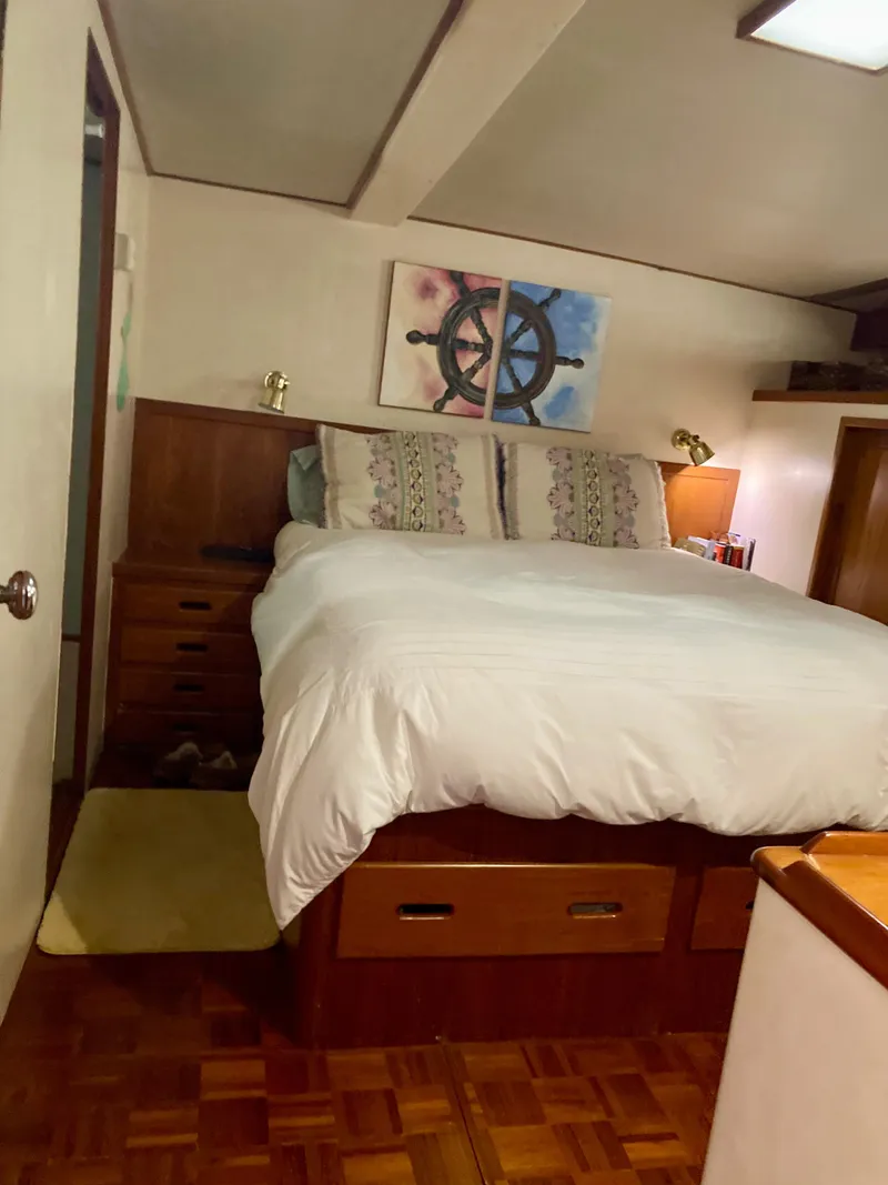 Slide: The Image of Cozy bedroom in 1977 Grand Alaskan Raised Pilothouse with nautical decor and wooden furnishings. - 13