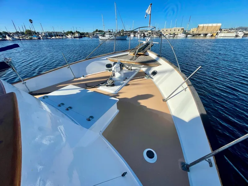 Slide: The Image of 1977 Grand Alaskan Raised Pilothouse yacht deck in a marina setting. - 25