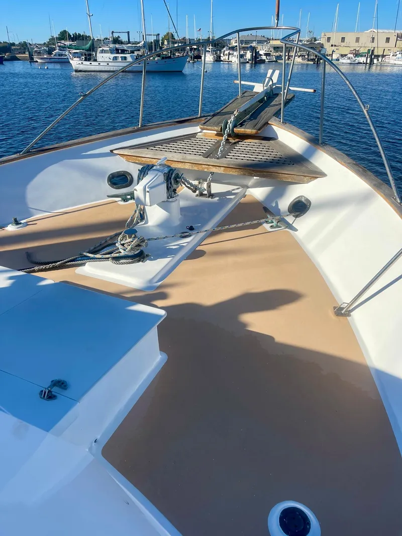 Slide: The Image of 1977 Grand Alaskan Raised Pilothouse yacht deck with anchor, docked in marina. - 26