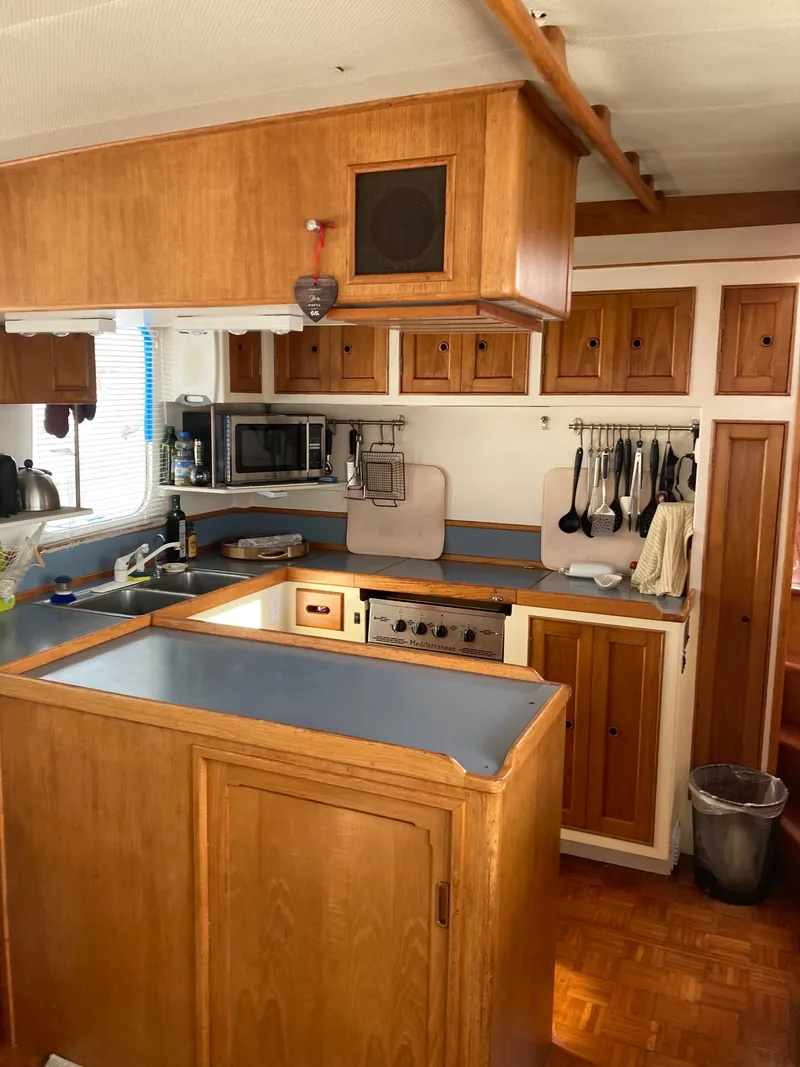 Slide: The Image of 1977 Grand Alaskan Raised Pilothouse kitchen with wooden cabinets and modern appliances. - 3