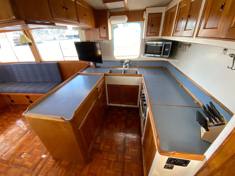 Slide: The Image of 1977 Grand Alaskan Raised Pilothouse kitchen with wood cabinetry and modern appliances. - 35