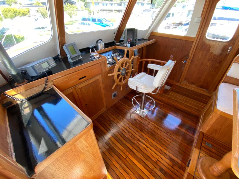Slide: The Image of Grand Alaskan Raised Pilothouse 1977 interior with wooden helm and navigation equipment. - 37