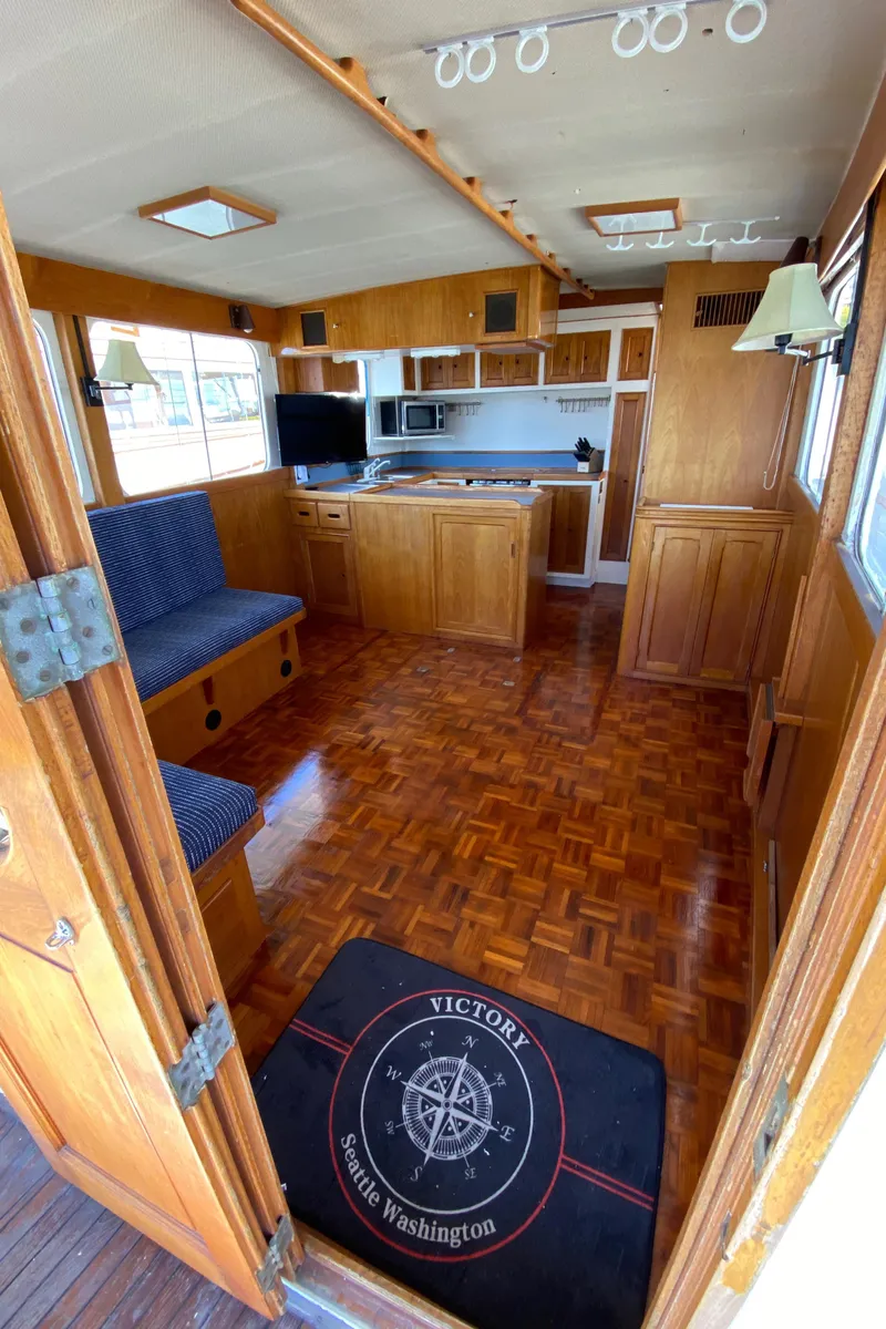 Slide: The Image of Interior of 1977 Grand Alaskan Raised Pilothouse with wood flooring and cozy seating area. - 38