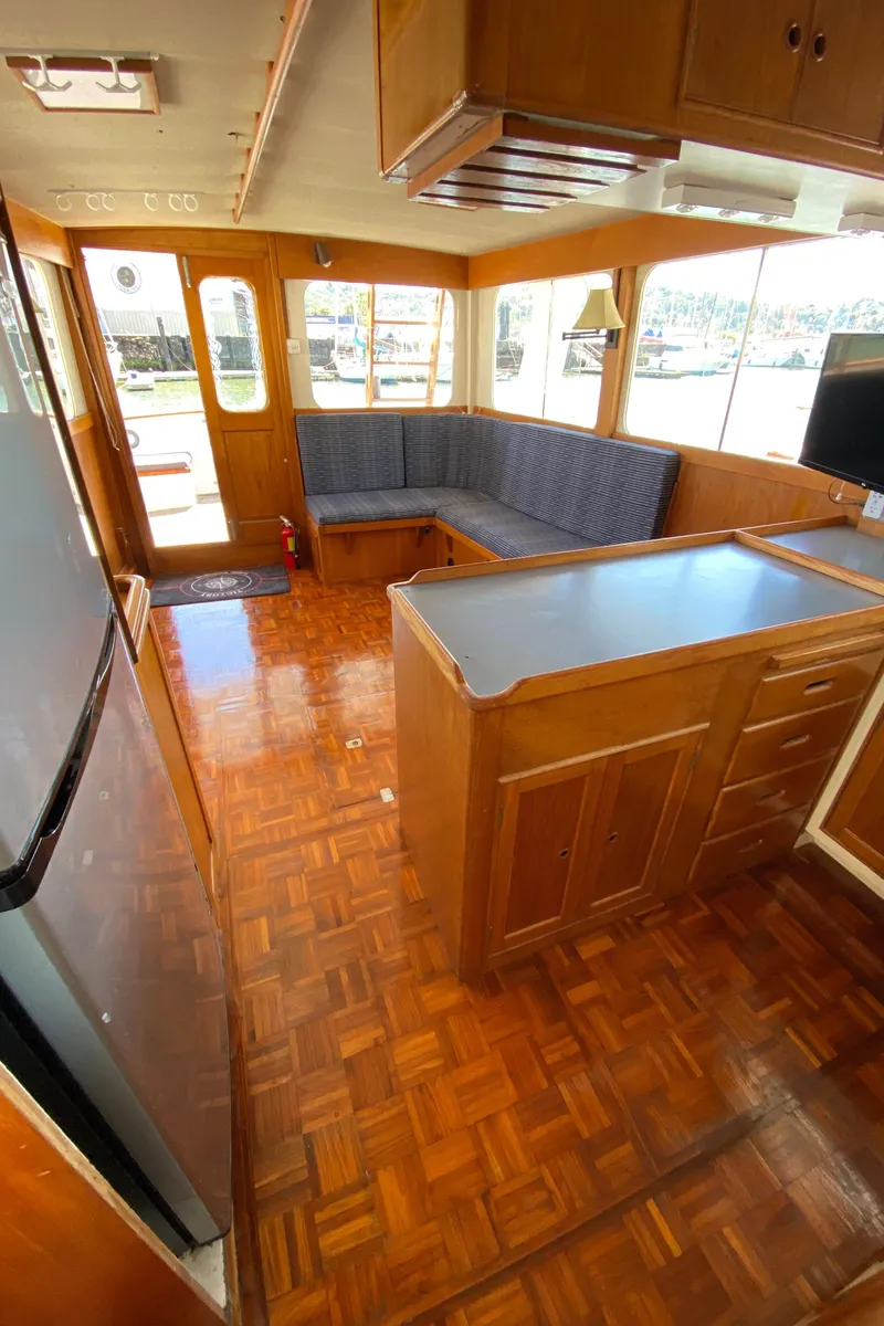 Slide: The Image of Interior of 1977 Grand Alaskan Raised Pilothouse with wood flooring and seating area. - 39