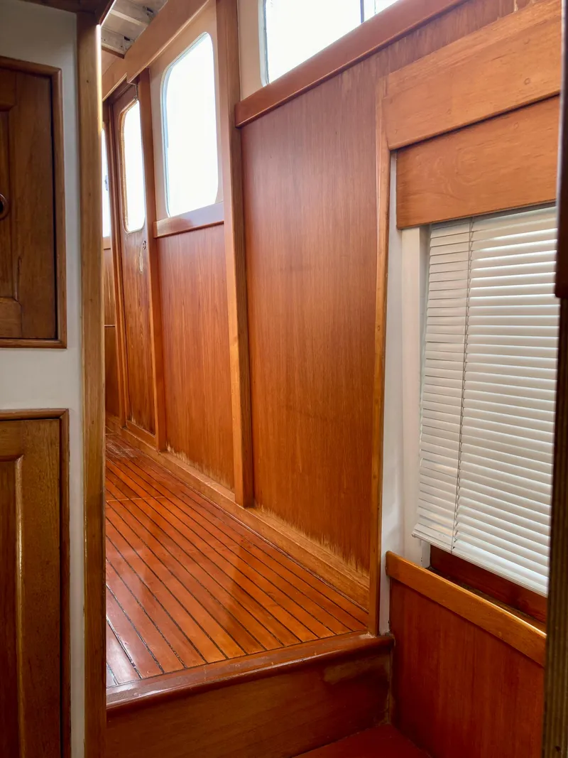 Slide: The Image of Interior of 1977 Grand Alaskan Raised Pilothouse with polished wood paneling and windows. - 4