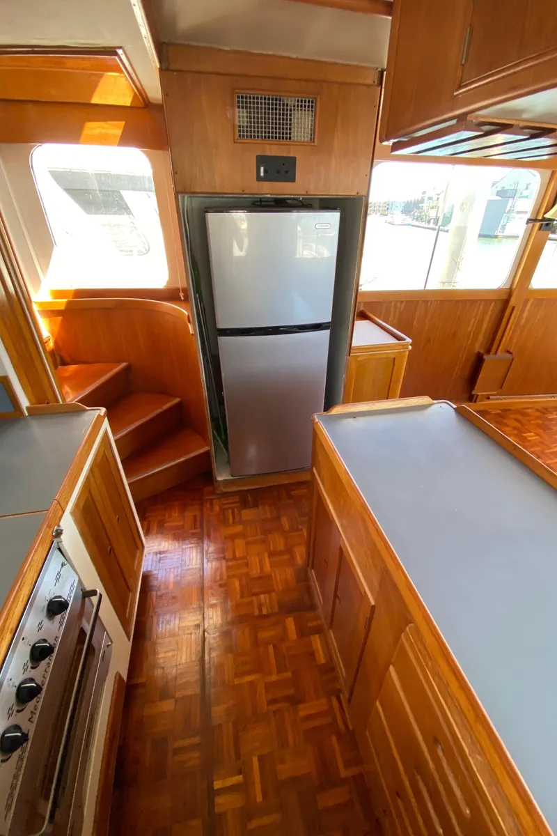 Slide: The Image of 1977 Grand Alaskan Raised Pilothouse kitchen with wood cabinetry and modern appliances. - 41