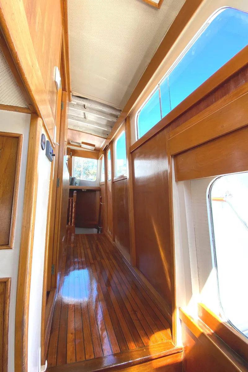 Slide: The Image of 1977 Grand Alaskan Raised Pilothouse interior with polished wood and large windows. - 44
