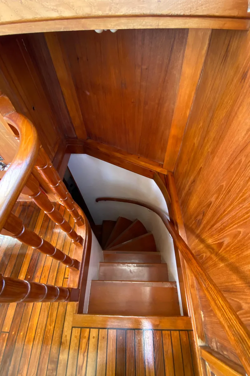 Slide: The Image of Wooden staircase inside 1977 Grand Alaskan Raised Pilothouse yacht, showcasing elegant craftsmanship. - 46