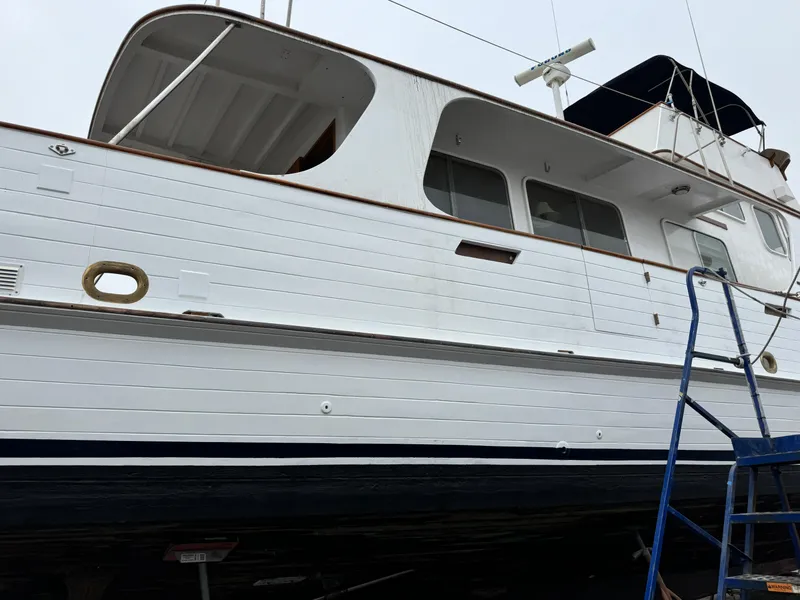Slide: The Image of 1977 Grand Alaskan Raised Pilothouse yacht on dry dock with blue ladder. - 47
