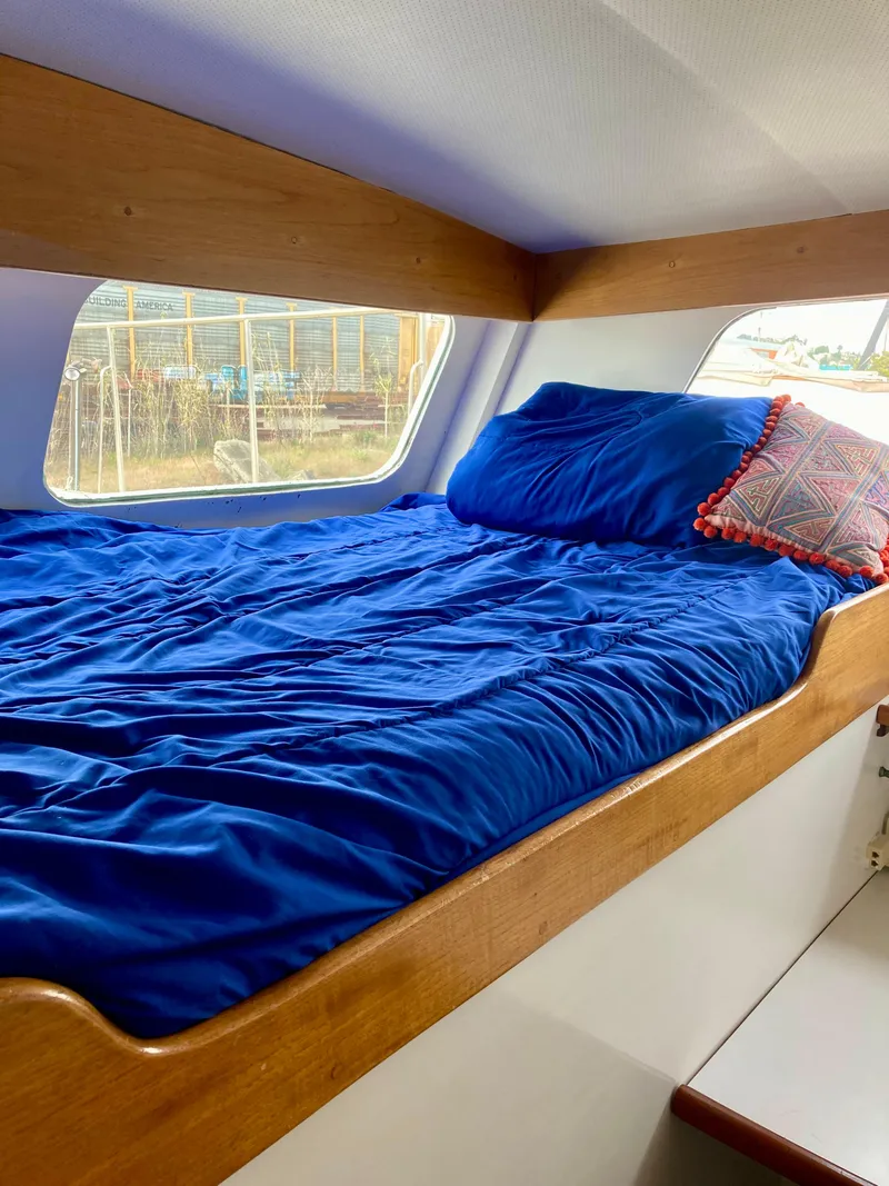 Slide: The Image of Cozy cabin bed in 1977 Grand Alaskan Raised Pilothouse with blue bedding. - 6