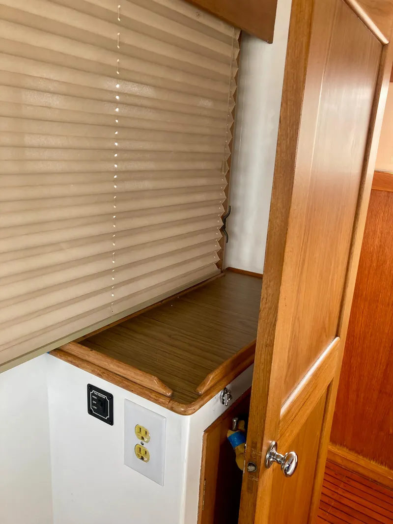 Slide: The Image of Interior of 1977 Grand Alaskan Raised Pilothouse with wooden cabinetry and blinds. - 7
