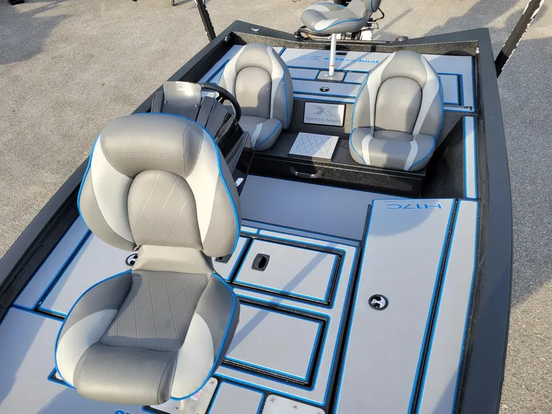 Slide: The Image of 2025 Xpress H17C Crappie boat interior with gray and blue seating, in stock. - 13